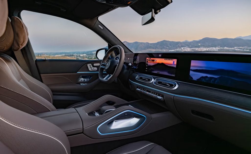 vehicle interior view, angled dashboard with dual screens and blue ambient lighting, leather seats, mountains outside window.