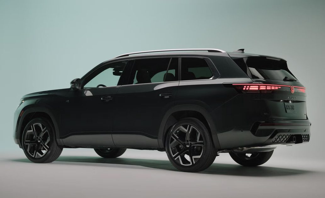 rear three quarter view, black suv on studio backdrop, illuminated taillights and clean minimalist background.