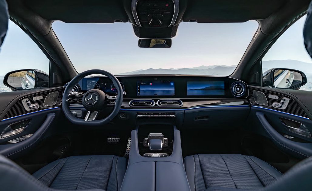 vehicle interior view, dual screens on dashboard, leather seats and ambient lighting, mountain horizon through windshield.