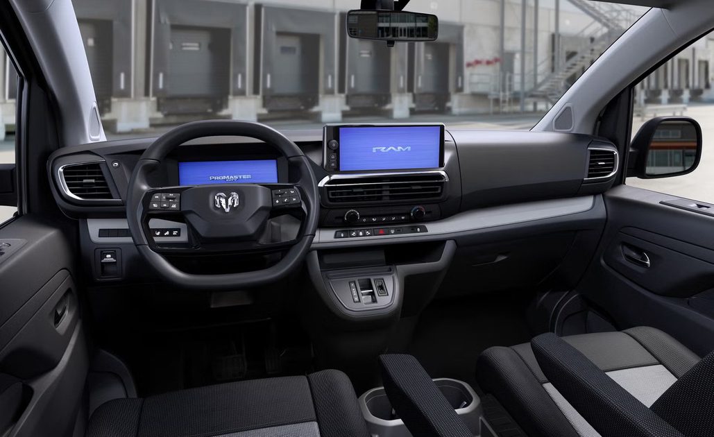 interior view dashboard steering wheel center display and front seats of cargo van parked near loading docks.
